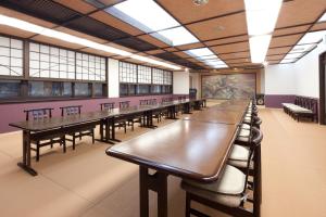 a row of tables and chairs in a room with windows at Kikunoya in Miyajima