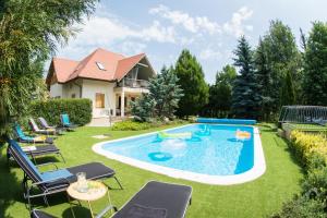 a backyard with a pool and chairs and a house at Villa Oliva Boutique Rooms & Spa Zamárdi in Zamárdi