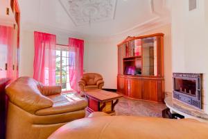 a living room with a couch and a tv at Villa Menir in Lagoa
