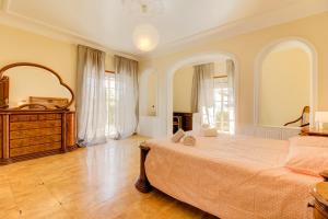 ein Schlafzimmer mit einem großen Bett und einem großen Fenster in der Unterkunft Villa Menir in Lagoa + 24 Fotos