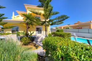 eine Villa mit Swimmingpool und Palmen in der Unterkunft Villa Menir in Lagoa