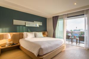 a bedroom with a large bed and a balcony at AVA SEA Ao Nang Beach Resort-SHA Extra Plus in Ao Nang Beach