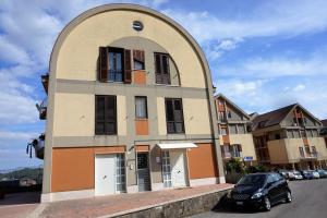 a building with an arched window and a car parked in front at Lucky's Home in Enna