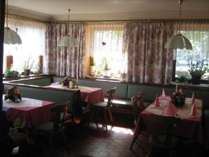 ノイマルクト・アム・ヴァラーゼーにあるGasthaus Eggerbergのピンクのナプキンを掛けたテーブル2台付きのレストラン