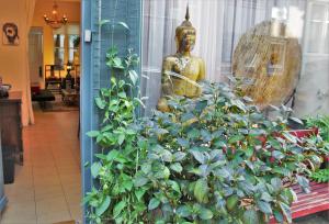 a statue in a store window with a plant at Amsterdam Lily apartment in Amsterdam