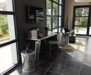 a living room with a table and chairs and windows at Hotel-Restaurant Lann Roz / Côte Cuisine in Carnac