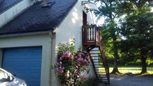 a house with a staircase and flowers on it at Calme et nature in Saint-Gravé