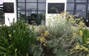 a garden with plants in front of a building at Hotel-Restaurant Lann Roz / Côte Cuisine in Carnac