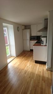 a kitchen with white appliances and a wooden floor at Stålemara Gård Krickan in Fågelmara