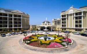 un grand bâtiment avec une fontaine au milieu d'une cour dans l'établissement Sunis Efes Royal Palace Resort & Spa, à Ozdere