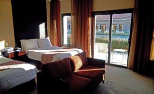 a hotel room with a bed and a chair and a window at Hotel Casino Magic in Neuquén