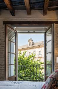 una camera da letto con finestra affacciata su un edificio di Santa Maria Apartments a Siviglia
