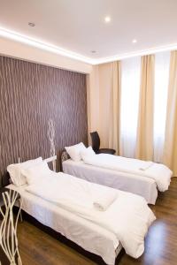 3 Betten in einem Hotelzimmer mit weißer Bettwäsche in der Unterkunft Cantry Ételbár in Balkány