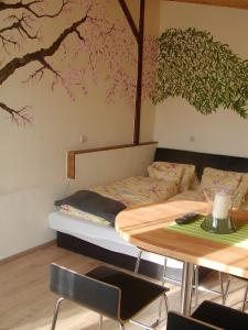 ティハニにあるKiserdei Apartmanのベッド1台、テーブル、木の壁画が備わるお部屋