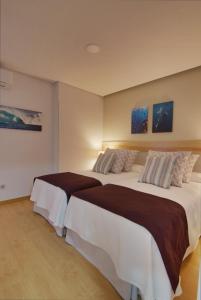 ラスパルマス・デ・グランカナリアにあるChic-Housing Las Canterasのベッドルーム1室(大型ベッド2台付)