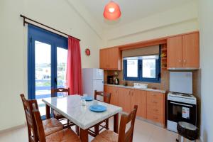 a kitchen with a table with chairs and a dining room at Kimothoy in Armenistis