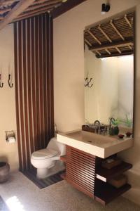 a bathroom with a sink and a toilet and a mirror at Santai Hotel in Amed