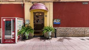 sklep z dwoma roślinami przed budynkiem w obiekcie Hosteria Villa de Castro w mieście Castro-Urdiales
