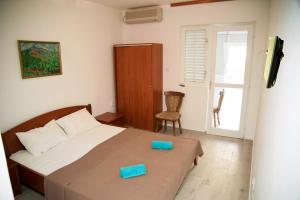 a bedroom with a bed with two blue boxes on it at GREJM Family Apartments in Petrovac na Moru +21 photos