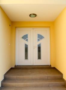 a white garage door with two windows in a room at Apartmani Marin in Vrbnik