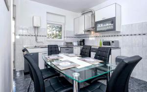 una cucina con tavolo in vetro e sedie nere di Apartment Maja a Spalato (Split)