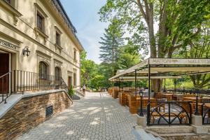 a sidewalk with tables and chairs next to a building at Hotel Malé Versailles in Karlovy Vary