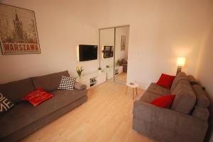 ein Wohnzimmer mit 2 Sofas und einem Spiegel in der Unterkunft Nowy Apartament Wilcza in Warschau