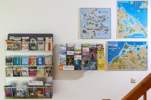 Eine Wand mit einem Haufen Bücher und einer Karte in der Unterkunft Hotel-Pension "Petridamm" in Rostock