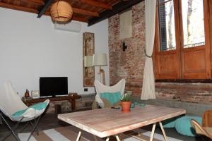 sala de estar con mesa de madera y sillas en Las Glicinas Boutique Apartments, en Colonia del Sacramento