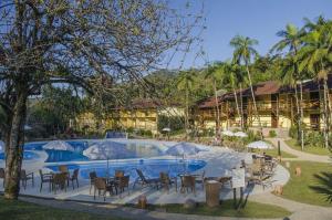 um resort com uma piscina com cadeiras e guarda-sóis em Hotel Fazenda Vale das Pedras em Jaraguá do Sul