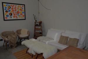 sala de estar con sofá blanco y mesa en Las Glicinas Boutique Apartments, en Colonia del Sacramento