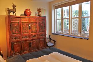 ein Schlafzimmer mit einem großen Holzschrank und einem Fenster in der Unterkunft Amsterdam Lily apartment in Amsterdam