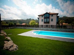 a house with a swimming pool in front of a yard at Hotel Villa Marrón in Naves