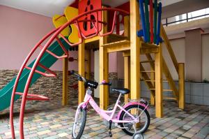 a pink bike parked in front of a playground at Hotel Elion in Zatoka