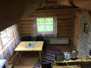 Pokój z drewnianym stołem i krzesłami w kabinie w obiekcie Ala-Laugu Holiday Home w mieście Leisi