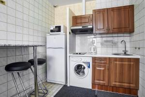 a small kitchen with a white refrigerator and a dishwasher at Winterfell on Kurskaya in Moscow