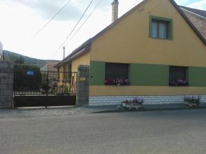 a house with flowers in the windows of it at Vogel Ági Vendégháza in Visegrád