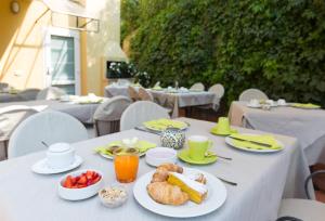 una mesa blanca con platos de comida. en Hotel Al Caval, en Torri del Benaco