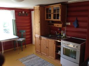 eine Küche mit roten Wänden, einem Herd und einer Spüle in der Unterkunft Løngdal in Tuddal
