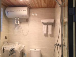y baño pequeño con ducha y aseo. en Manifeng Apartment Hotel, en Guiyang