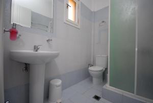 Baño blanco con lavabo y aseo en Pension Stella, en Naxos Chora