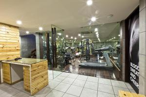 a gym with treadmills and machines in a room at Hotel El Dorado in Ahmedabad