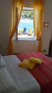 a bedroom with a bed and a window with a view at Villa Glicine in Ponza