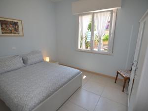 ein weißes Schlafzimmer mit einem Bett und einem Fenster in der Unterkunft Belvilla by OYO Venturi Olive in Gatteo a Mare