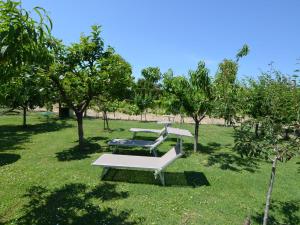 ein Park mit zwei Bänken im Gras in der Unterkunft Belvilla by OYO Venturi Olive in Gatteo a Mare