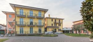 een geel gebouw met balkons aan de zijkant bij Hotel Colombera Rossa in Brescia