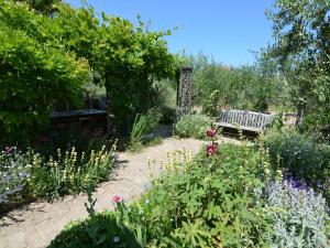 um jardim com um banco e algumas flores em Belvilla by OYO Venturi Cherry em Gatteo a Mare