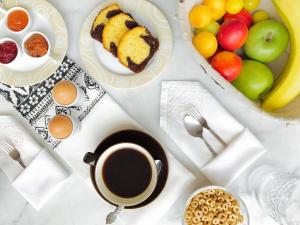 a table with a cup of coffee and a bowl of fruit at Calypso Beach Hotel in Loutra Edipsou