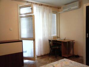 ヴァルナ・シティにあるApartment Dimitrovのデスク、テーブル、窓が備わる客室です。