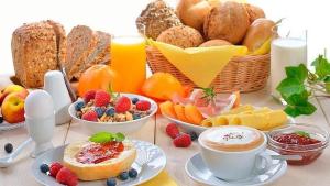 - une table avec des aliments pour le petit-déjeuner, du café et des fruits dans l'établissement Hospedaje La Anita, à Lima